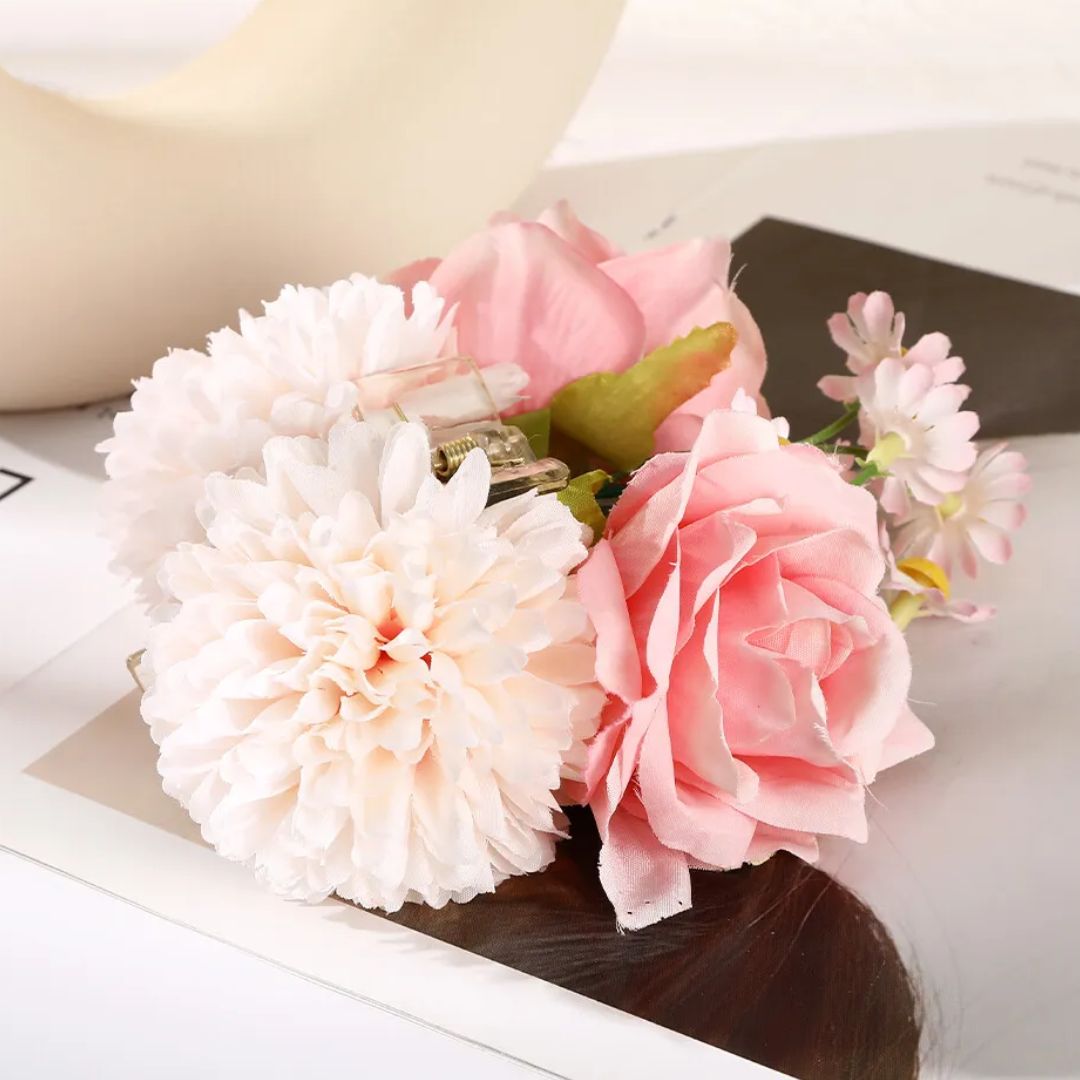 Künstliche Blumenarrangement mit rosa und weißen Blüten auf Zeitschrift, dekorativ.