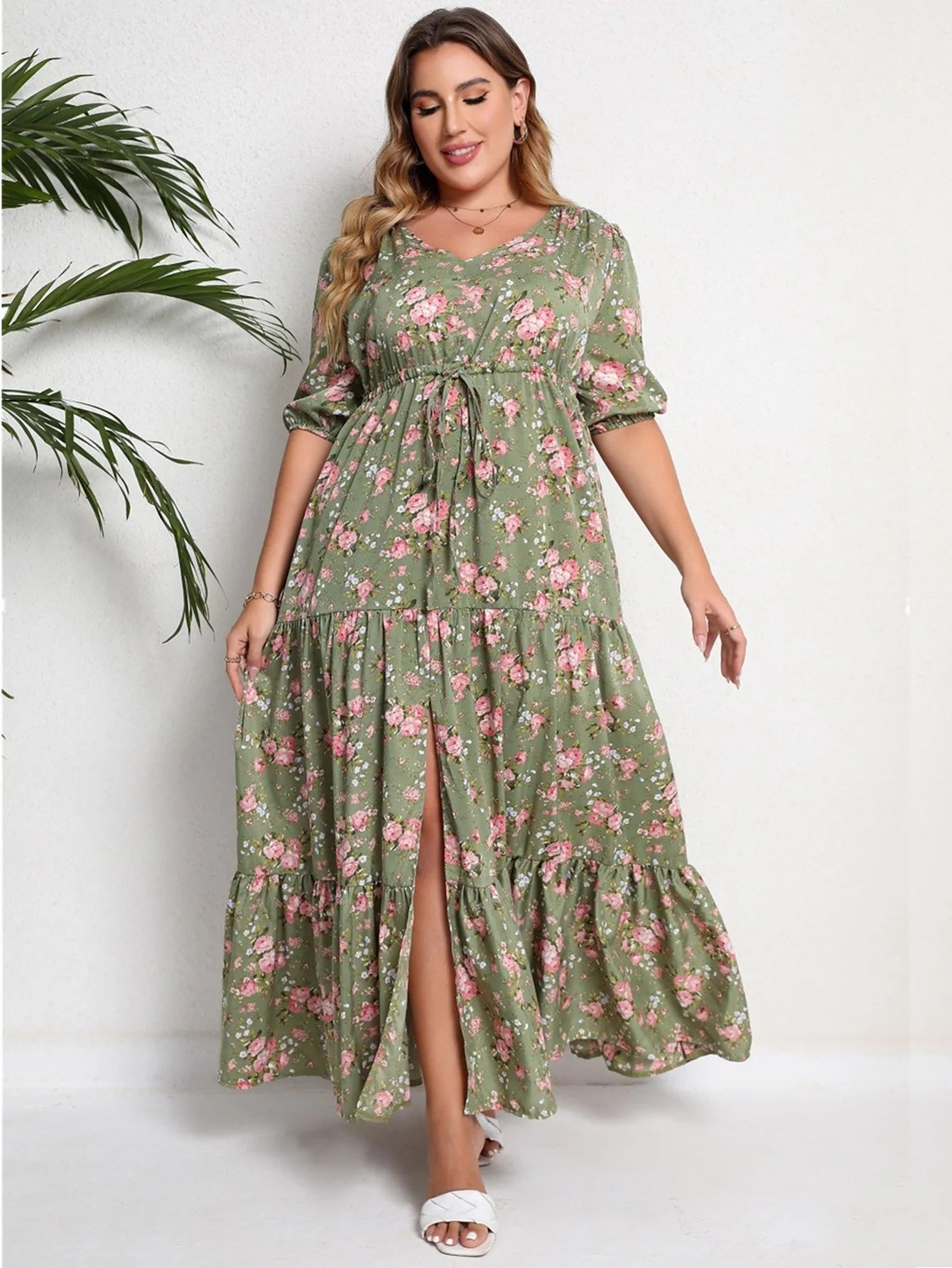 Frau im grünen Maxikleid mit Blumenmuster, V-Ausschnitt, Dreiviertelärmel, Sommermode.