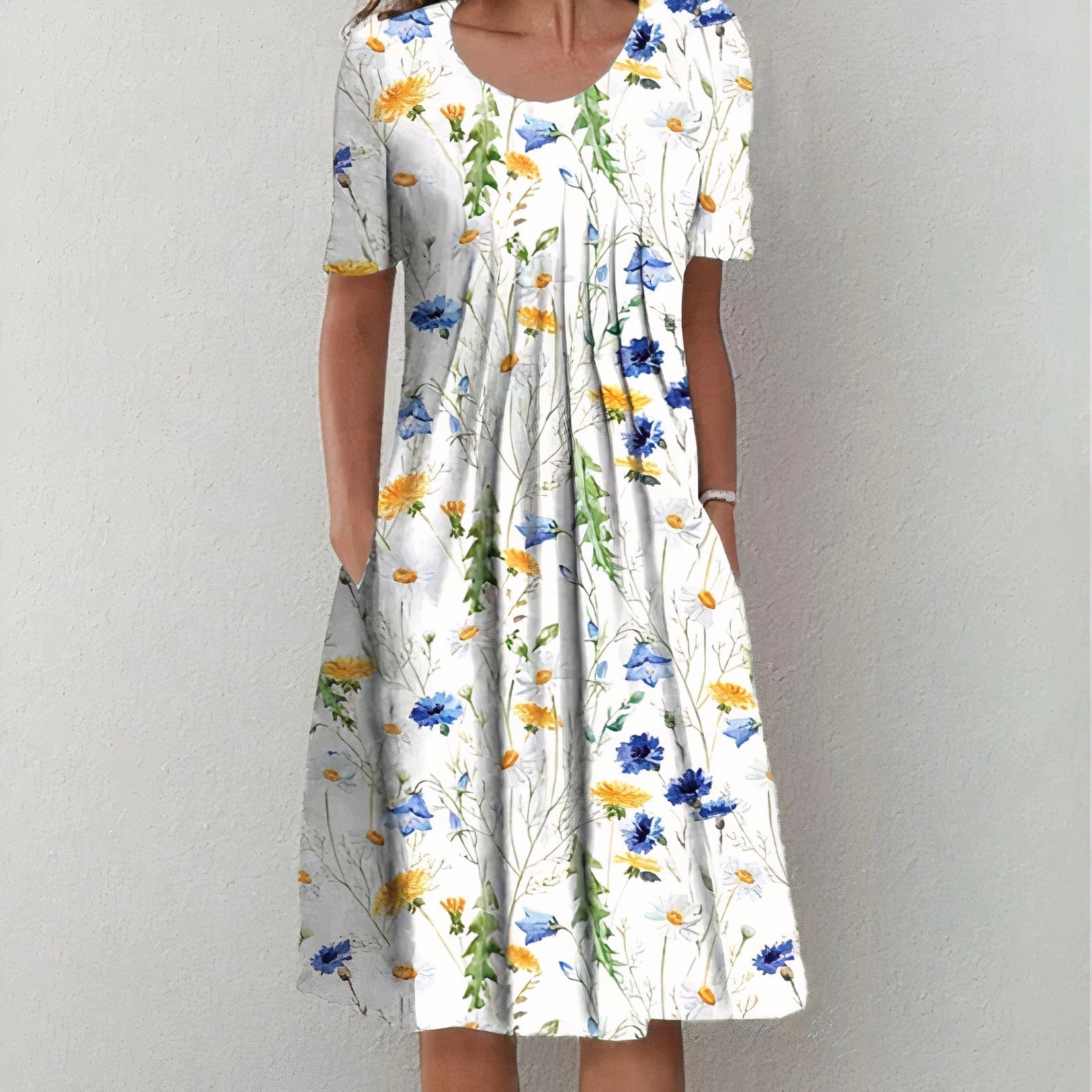 Frau in weißem Sommerkleid mit Blumenmuster, kurzärmelig, knielang, lässig, elegant.