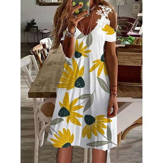 Frau in weißem Sommerkleid mit gelbem Blumenmuster, schulterfrei, im Wohnzimmer.
