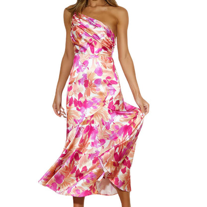 Frau in einem schulterfreien, pink-orange geblümten Seidenkleid, elegant und sommerlich.