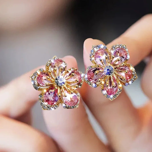 Goldene Blumenohrringe mit rosa Kristallen, funkelnd, elegant, Modeschmuck, Damenaccessoire.