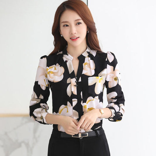 Frau in schwarzer Bluse mit Blumenmuster, elegant, Büro-Outfit, Damenmode, Langarm, modern.