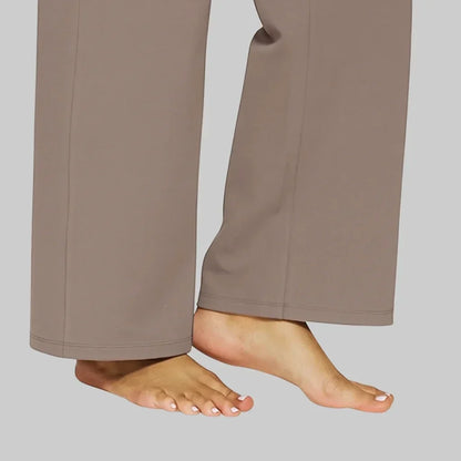 Detailansicht des geraden, weiten Beinabschlusses der taupefarbenen Hose mit Saumnaht, barfuß getragen. 5