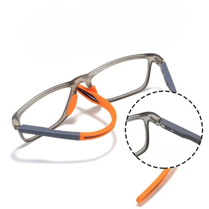 Brille mit grauem Rahmen, die flexiblen orangefarbenen Bügelenden sind abgebogen; Ausschnittvergrößerung zeigt das Scharnier am Bügel. 10