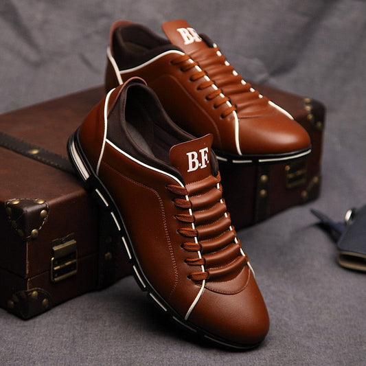 Braune Herrensneaker aus Leder mit weißer Sohle, stilvoll und modern, auf Koffer platziert.