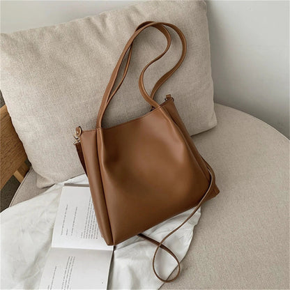 Braune Ledertasche auf beigem Sessel, modisch, elegant, Damenhandtasche, minimalistisches Design.