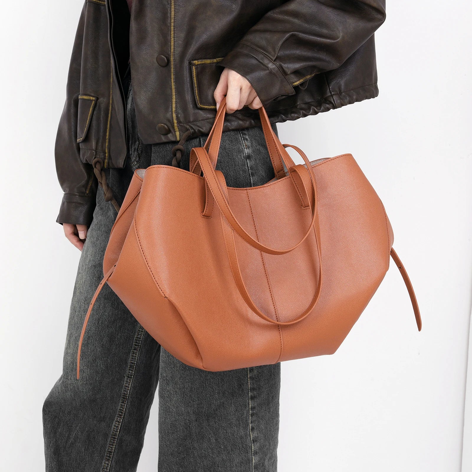 Frau mit brauner Ledertasche, lässiger Stil, Damenmode, große Handtasche, Alltagsgebrauch.