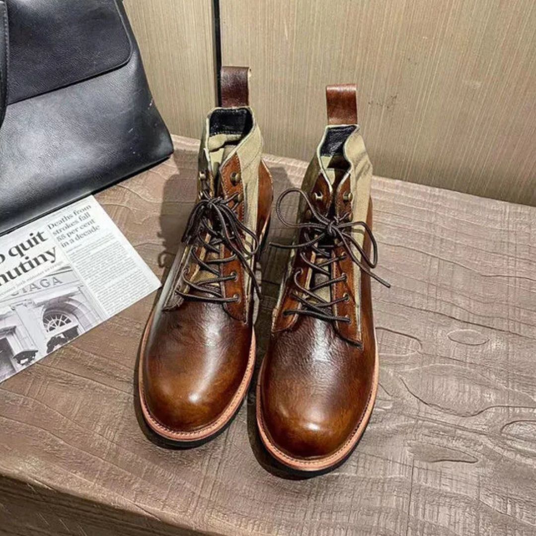 Braune Lederstiefel mit Schnürung auf Holztisch, modisch, hochwertig, Herrenschuhe.