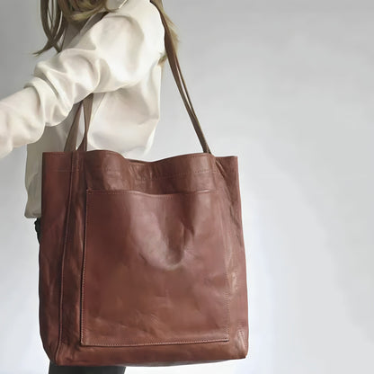 Frau mit großer brauner Ledertasche, modisches Accessoire, elegantes Design.