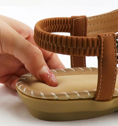 Braune Sandale mit geflochtenem Riemen, bequeme Sohle, Damenmode, Sommer, Nahaufnahme.