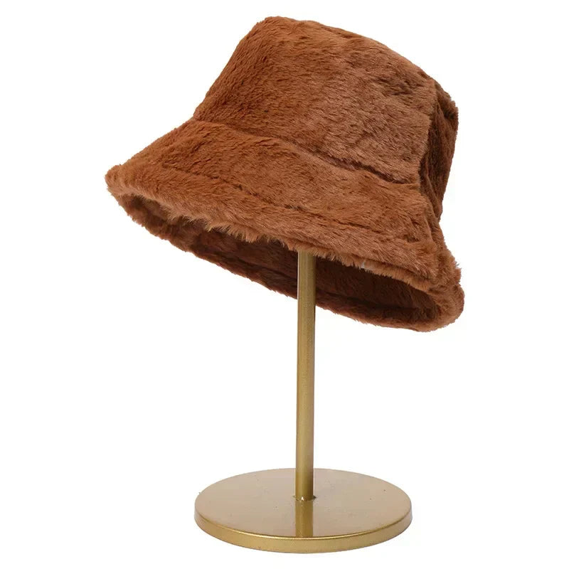 Brauner Kunstpelz-Bucket-Hut auf goldenem Ständer, modisches Accessoire, Herbst-Winter-Trend.