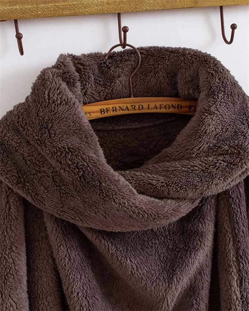 Brauner, flauschiger Fleece-Mantel auf Holzbügel, Wintermode, warm, gemütlich.