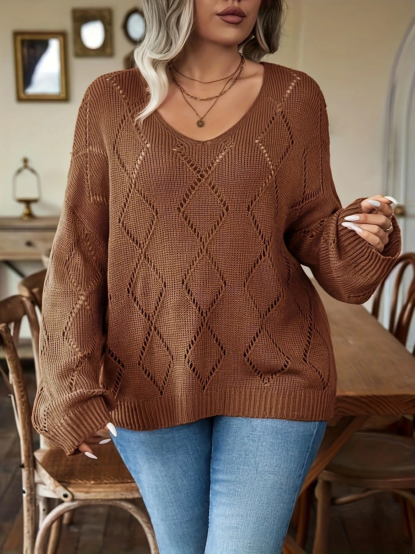 Frau in braunem Strickpullover mit Rautenmuster, blaue Jeans, modisch, gemütlich, Herbstmode.