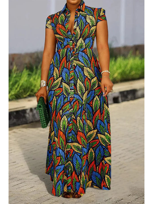 Frau in langem, buntem Kleid mit Blattmuster, grüne Clutch, Sommermode, elegant.