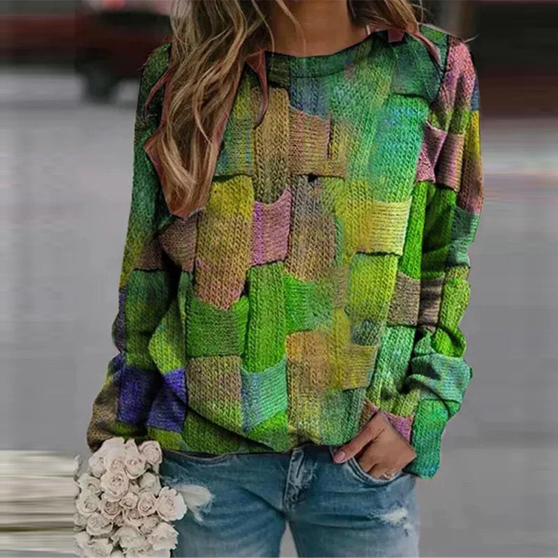 Frau in buntem Strickpullover, Jeans, hält weiße Rosen; modische Damenbekleidung.