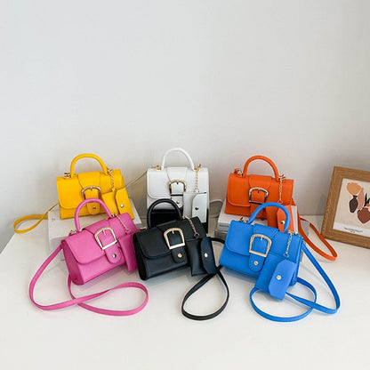 Sechs bunte Mini-Handtaschen mit Schnallen, Lederoptik, in Gelb, Weiß, Orange, Pink, Schwarz, Blau.