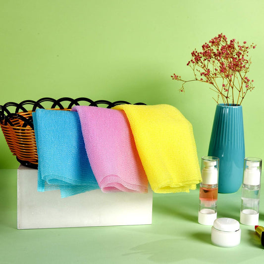 Bunte Handtücher im Korb, blau, rosa, gelb, auf grünem Hintergrund, dekorative Vase, Hautpflegeprodukte.