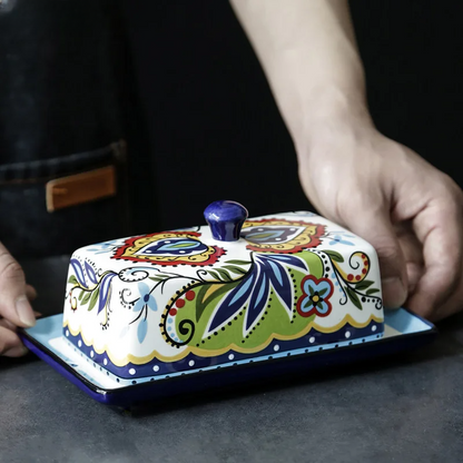 Bunte handbemalte Butterdose aus Keramik mit floralem Design, ideal für Küche und Tischdekoration.