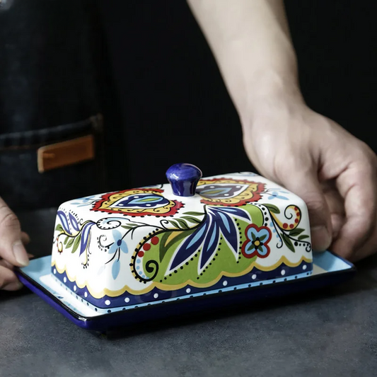 Bunte handbemalte Butterdose aus Keramik mit floralem Design, ideal für Küche und Tischdekoration.