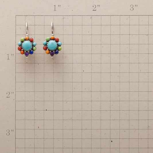 Bunte Ohrringe mit Türkis und bunten Perlen auf kariertem Hintergrund, handgefertigter Schmuck.