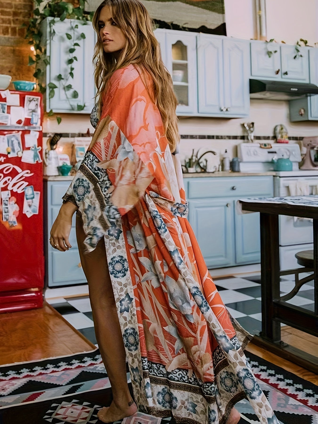 Frau in langem, buntem Kimono in Küche, Retro-Kühlschrank, Boho-Stil, Mode, Innenraum.