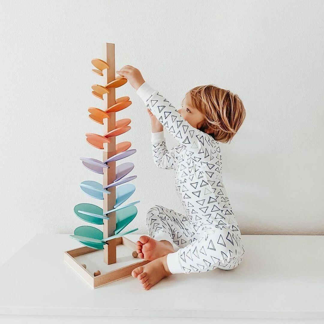 Kind spielt mit buntem Holzspielzeug, Montessori, motorische Fähigkeiten, pädagogisch, nachhaltig.