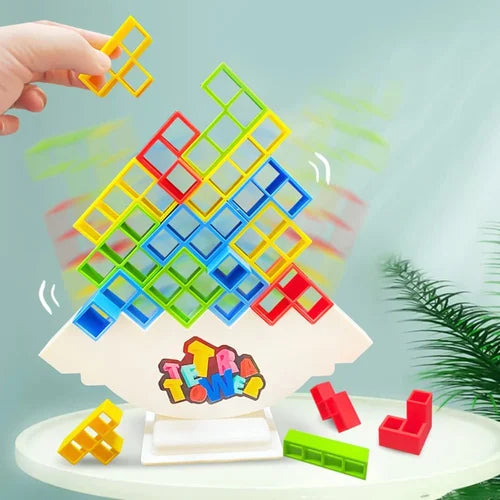 Buntes Tetris-Balancespiel aus Kunststoff, Hand hält gelbes Teil, auf weißem Tisch.