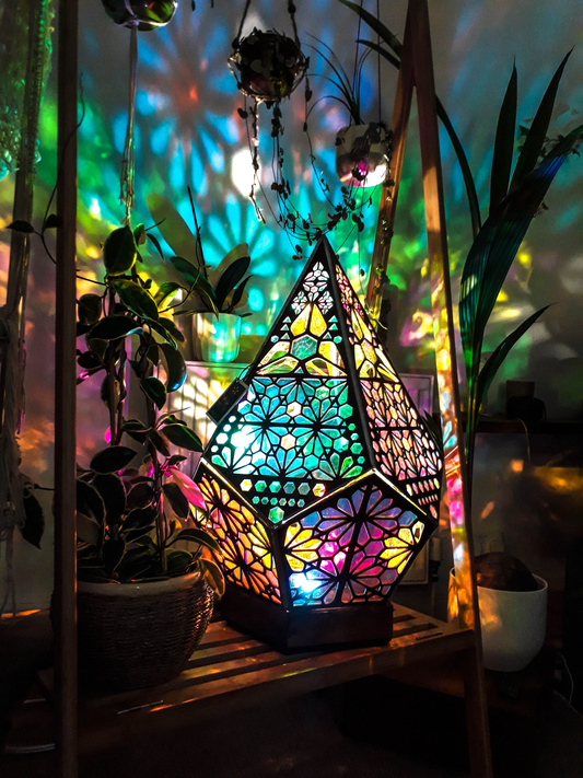 Buntes geometrisches Nachtlicht, Holzrahmen, projiziert farbenfrohe Muster, dekorative Beleuchtung.