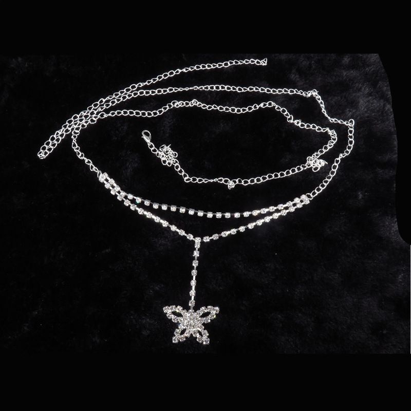 Silberne Schmetterlingskette mit Strasssteinen auf schwarzem Hintergrund, eleganter Schmuck.