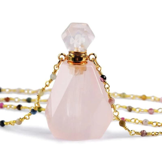 Rosenquarz Parfümflakon mit goldener Kette, facettiert, edelsteinbesetzt, luxuriöses Design.