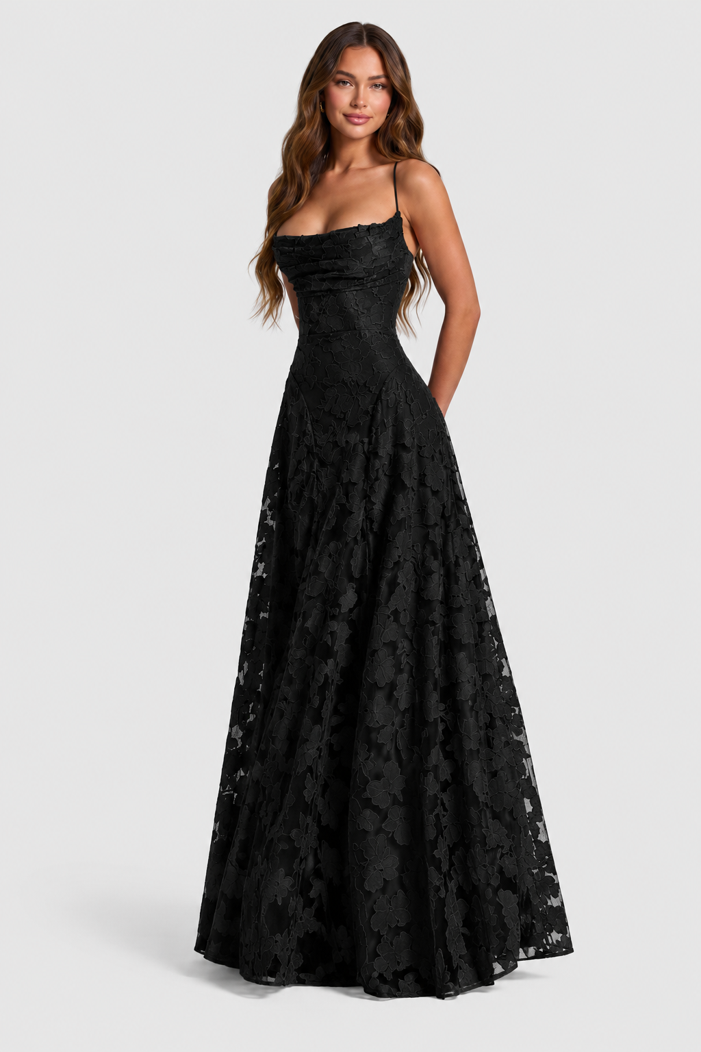 Model trägt das schwarze Spitzenkleid mit Wasserfallausschnitt und dünnen Trägern in Dreiviertelansicht, der weit ausgestellte Rock fällt bis zum Boden. 21