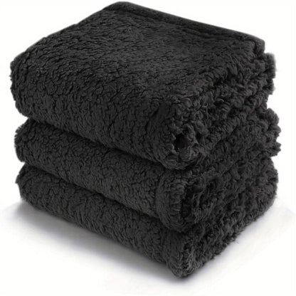 Dunkle, flauschige Fleece-Decke, gestapelt, weich, warm, ideal für Sofa oder Bett.