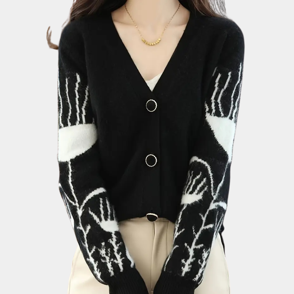 Frau in schwarzem Cardigan mit weißem Muster, V-Ausschnitt, Knöpfen, beige Hose.