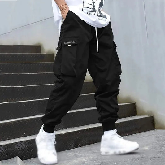 Schwarze Herren-Cargo-Jogginghose mit Taschen, Streetwear, Hip-Hop-Stil, Treppe, weiße Sneaker.