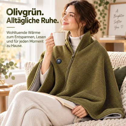 Frau mit Tasse und Buch auf dem Sofa, eingehüllt in die olivgrüne Heizdecke mit grauem Fleecefutter 8