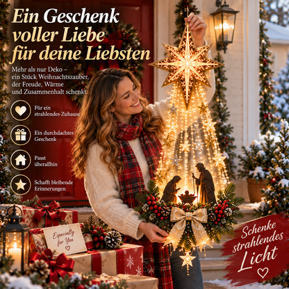 Lächelnde Frau in Schal hält die leuchtende Dekoration mit Stern und Krippe vor sich, umgeben von Geschenken 9