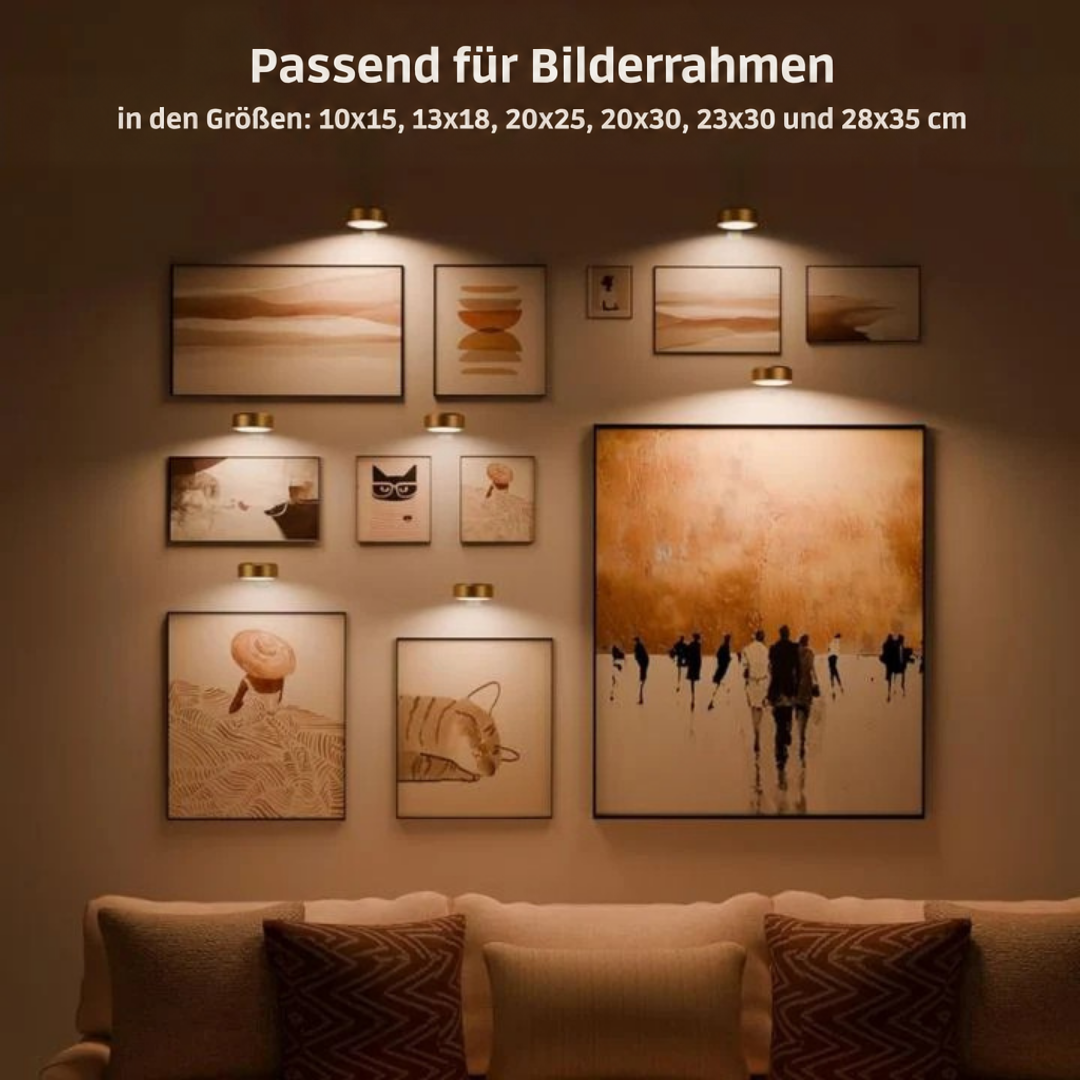 Mehrere kleine goldene Bilderleuchten beleuchten eine Galeriewand mit Bildern in verschiedenen Größen über einem Sofa 2