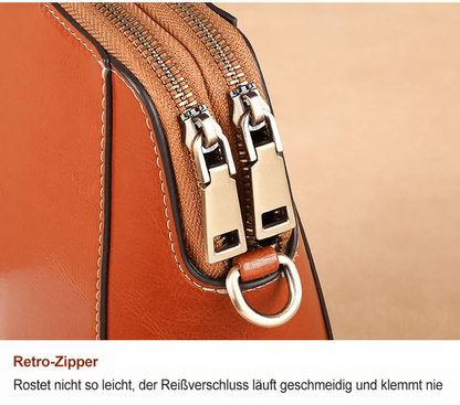 Nahaufnahme der beiden Reißverschlussläufer in Altmessing-Optik mit D-Ring an der braunen Tasche 13