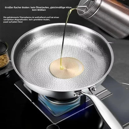 Öl wird in die Mitte der gehämmerten Pfanne gegossen, die auf einer Gasflamme steht; der ebene Boden ist erkennbar. 7