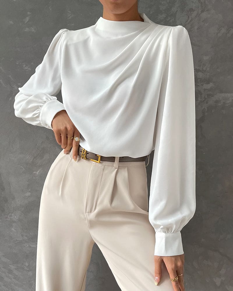 Weiße Bluse mit langen Ärmeln, elegantes Design, Damenmode, vor grauem Hintergrund.
