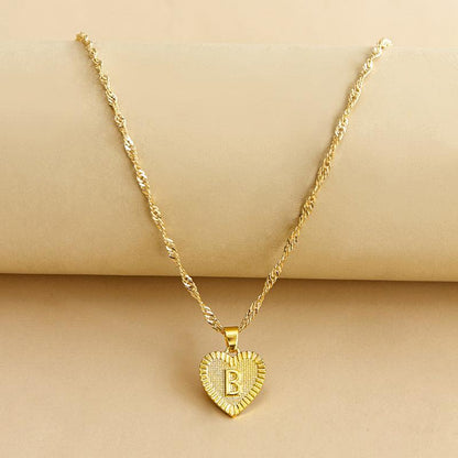 Goldene Herz-Halskette mit Buchstabenanhänger, gedrehtes Kettendesign, eleganter Schmuck.