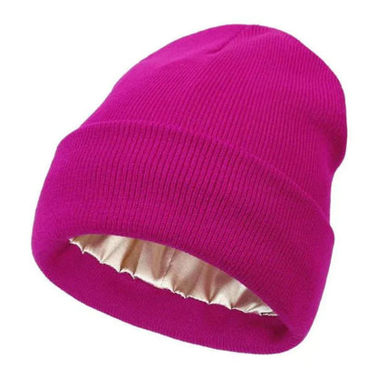 Pinkfarbene Strickmütze mit Umschlag, innen mit goldbeigem Satinfutter, einzeln freigestellt 13