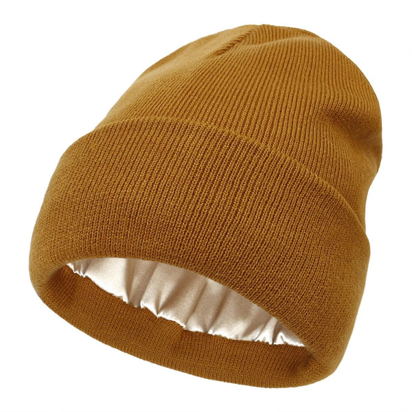 Senfgelbe Strickmütze mit Umschlag, innen mit glänzendem cremefarbenem Satinfutter, einzeln freigestellt 1