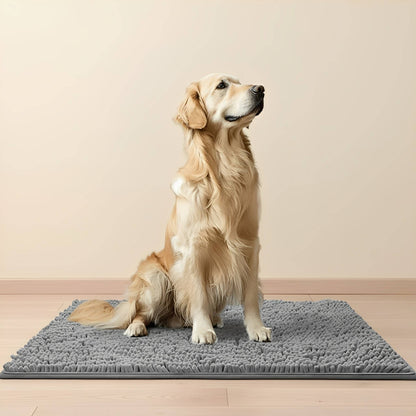 Ein Golden Retriever sitzt aufmerksam auf einer grauen Chenille-Fußmatte auf einem hellen Holzboden vor einer beigen Wand. 1