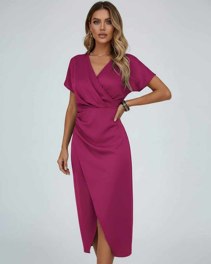 Model in beerenfarbenem Wickelkleid mit V-Ausschnitt, eine Hand an der Hüfte, Frontansicht 1
