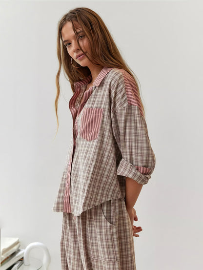 Model im rosa-beige karierten Pyjama-Set mit rosa gestreiftem Kragen und aufgesetzter Brusttasche, seitlich gedreht, die Arme hinter dem Rücken. 2