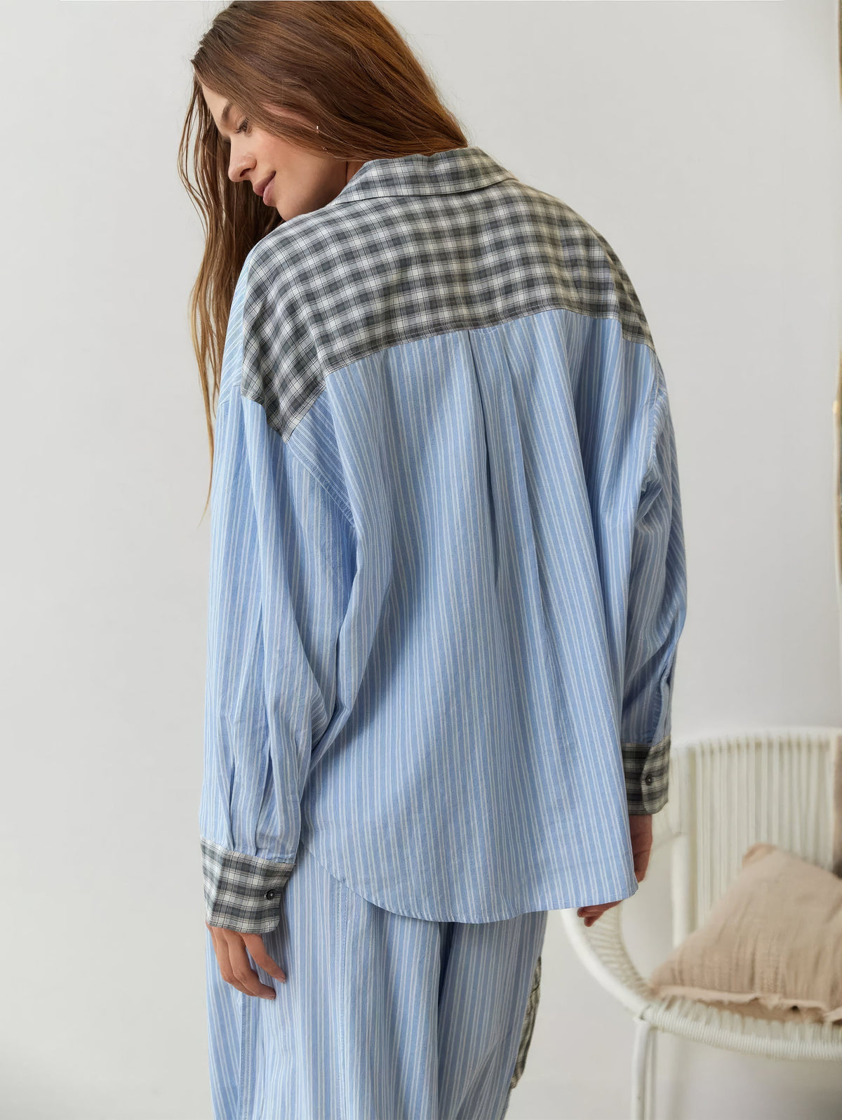Rückansicht des blau gestreiften Pyjama-Hemds mit grau kariertem Schulterpasse und karierten Manschetten, das Model blickt nach unten. 9