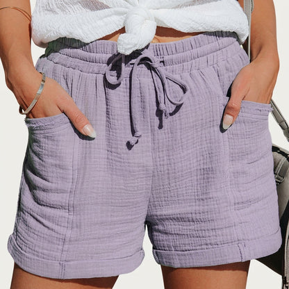 Dieselben Shorts in zartem Flieder, getragen mit weißem Knotenoberteil, Kordelzug an der Taille und umgeschlagenen Säumen. 2