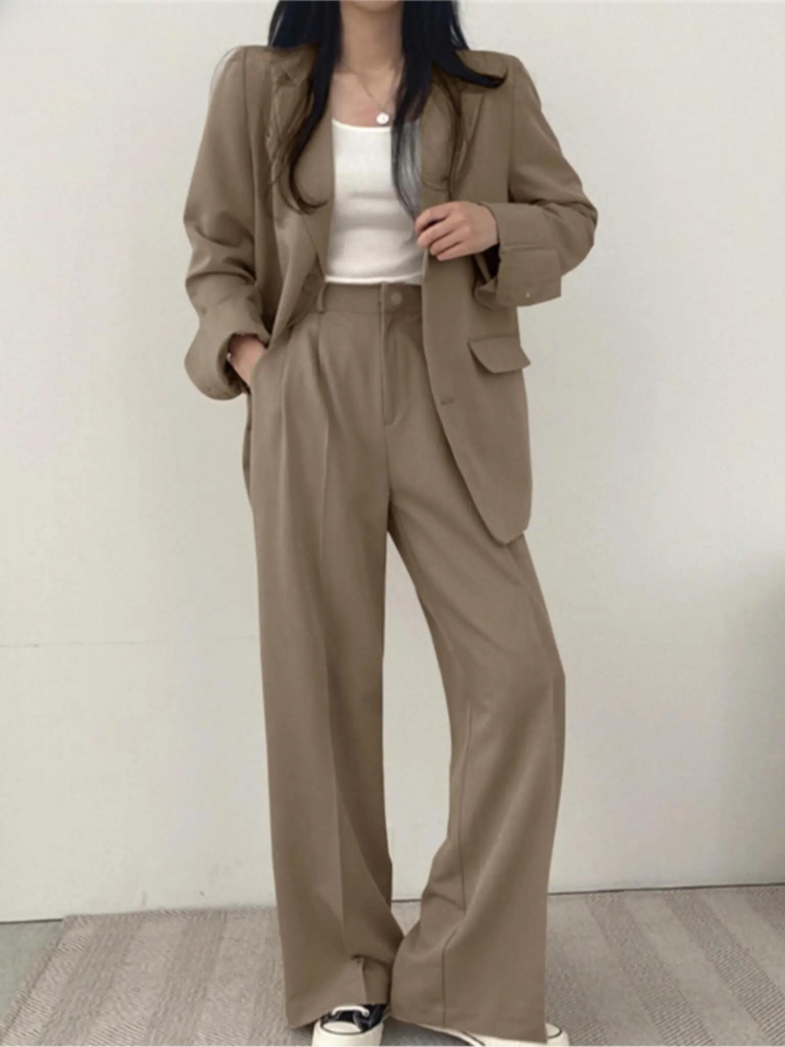 Frau in beigem Anzug mit weißem Top, lässiger Business-Look, Mode für Damen.